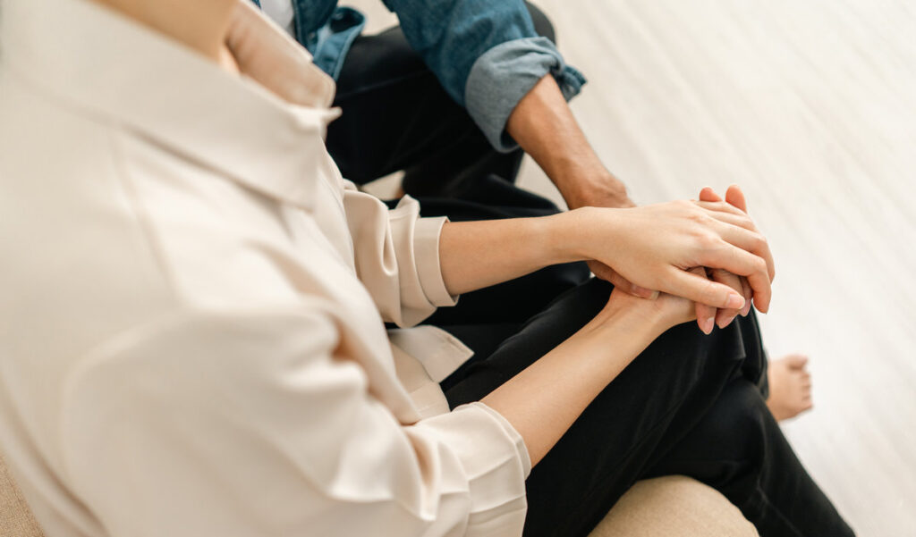 Happy asian Couple hugging on the day of the start of family life pregnant woman sitting on a couch in the living room at home. Counseling for fertility and pregnancy Becoming Parents