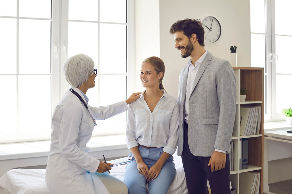 Smiling couple meeting with a fertility doctor for a pregnancy planning consultation